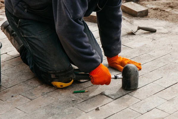 the process of laying tiles with a rubber mallet