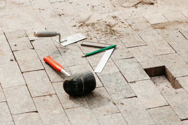 corner, putty knife and rubber mallet lies on the ground