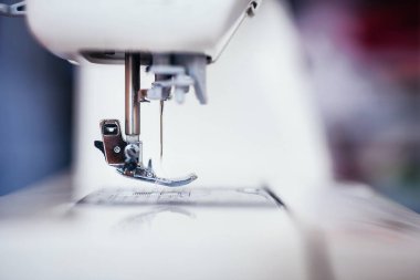 Dikiş makinesine basılı ayağını ve mekiğini yakın plan çek
