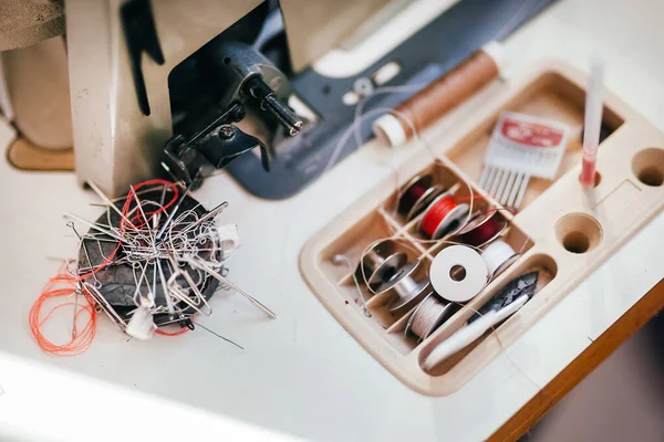 Different sewing tools lie near the sewing machine