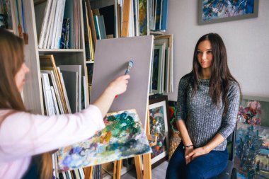 Kız ressam bir erkeği doğadan resmeder.