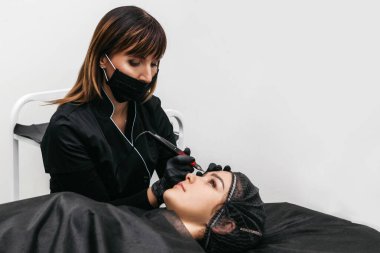 Profesyonel güzellik uzmanı kalıcı makyaj yapıyor.