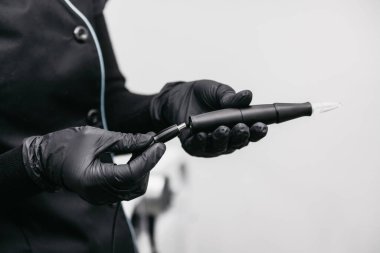 Güzellik uzmanı kalıcı makyaj için bir kablo makinesine bağlanır.