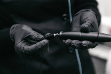 Güzellik uzmanı kalıcı makyaj için bir makine bağlar