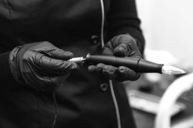 Güzellik uzmanı kalıcı makyaj için bir kablo makinesine bağlanır.