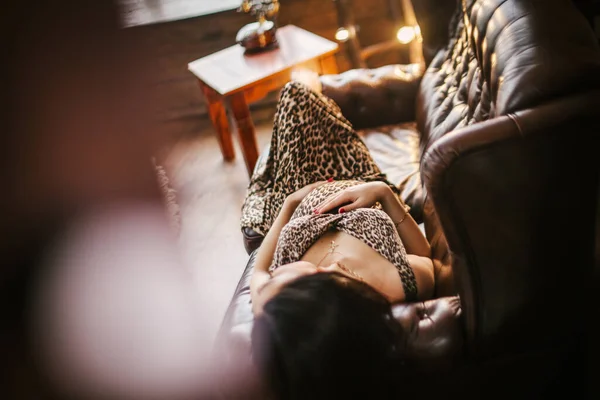 Schwangere Hält Hände Auf Bauch Und Liegt Auf Sofa — Stockfoto