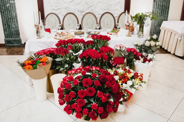 table for five people. In the foreground a lot of flowers