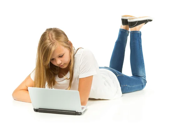 Chica joven acostada en el suelo con el ordenador portátil sobre fondo blanco — Foto de Stock