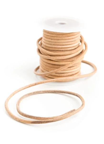 Brown leather cord on plastic spool — Stock Photo, Image