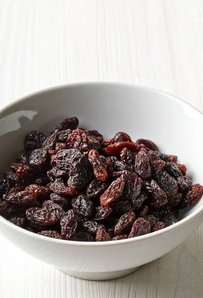 Organic raisins in white bowl — Stock Photo, Image