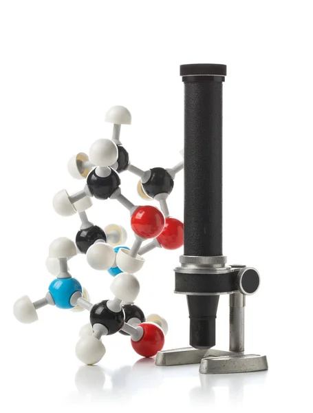 Modèle de molécule chimique avec vieux microscope sur fond blanc — Photo