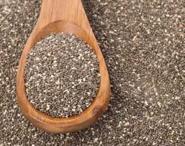 Tahta kaşık chia tohumları üzerinde ham işlenmemiş siyah chia tohum