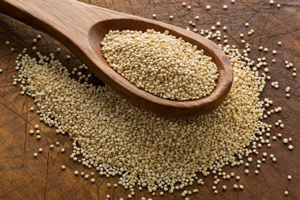 Syrové, celozrnný, nezpracovaný quinoa semena v vařečku na dřevo kance — Stock fotografie