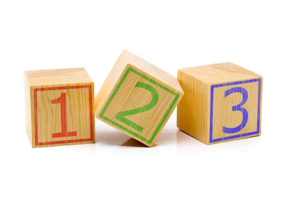 Три коричневых деревянных кубика, выстроенных в ряд с номерами один, два — стоковое фото