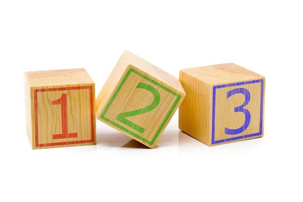 Three brown wooden cubes lined up in a row with numbers one, two Stock Photo