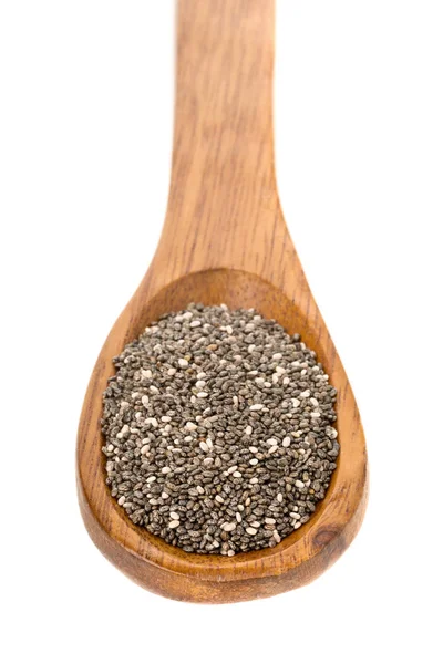 Whole dried black chai seeds in wooden spoon — Stock Photo, Image