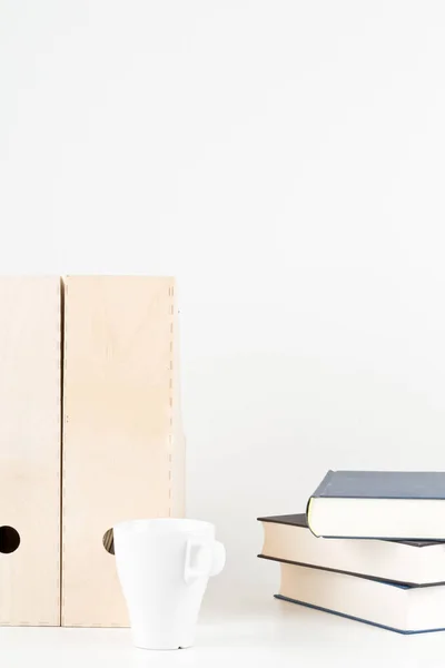 Escritorio de oficina blanco con libros, taza y carpetas — Foto de Stock