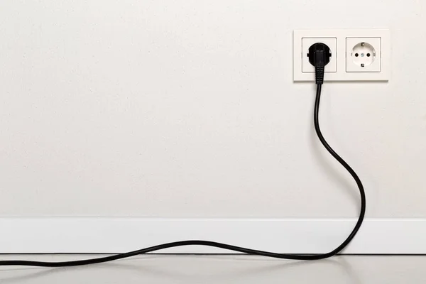 Černá napájecí kabel kabel zapojen do Evropské zásuvky na Svatodušní — Stock fotografie