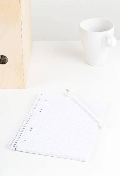 Escritório branco com bloco de notas vazio, lápis, xícara e pastas — Fotografia de Stock