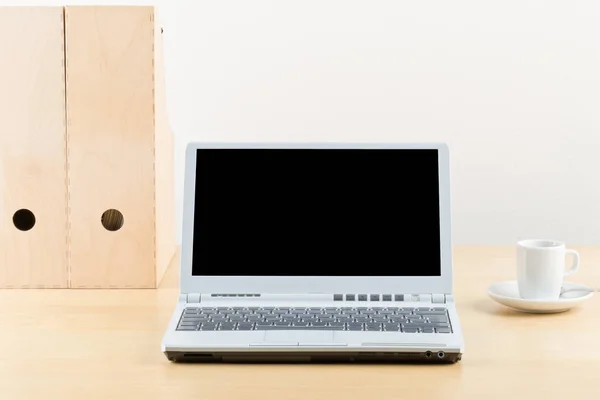 Bureau met cup, mappen en laptop — Stockfoto