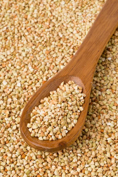 Raw, natural, uncooked buckwheat seed kernels in wooden spoon — Stock Photo, Image