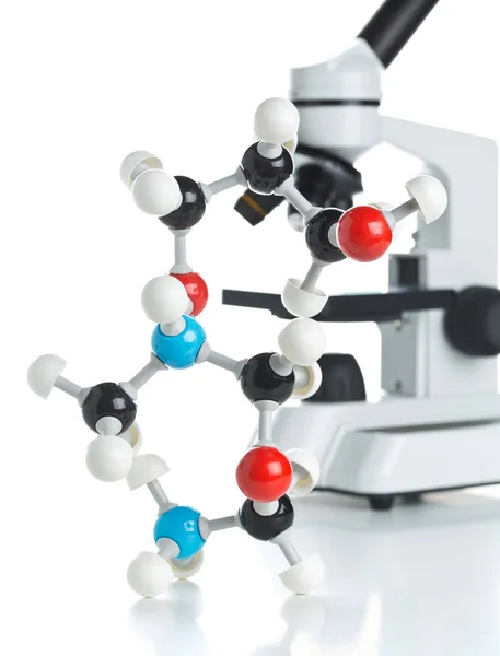 Microscope with molecule model on table — Stock Photo, Image