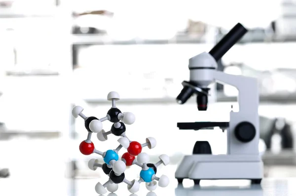 Microscopio con modelo de molécula en laboratorio —  Fotos de Stock