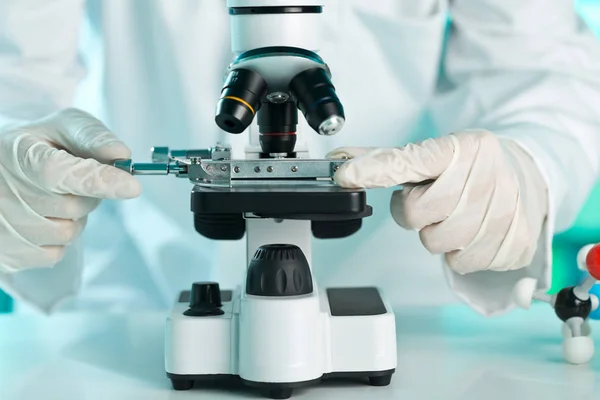 Forscher arbeiten mit Probenplatte am Mikroskop — Stockfoto