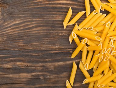 Çiğ, çiğ, Kuru penne makarna erişte üzerinde rustik kahverengi wo sınır