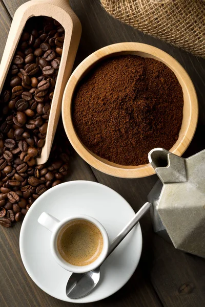 Chicchi di caffè, polvere di caffè macinato e tazza di caffè espresso con stov — Foto Stock