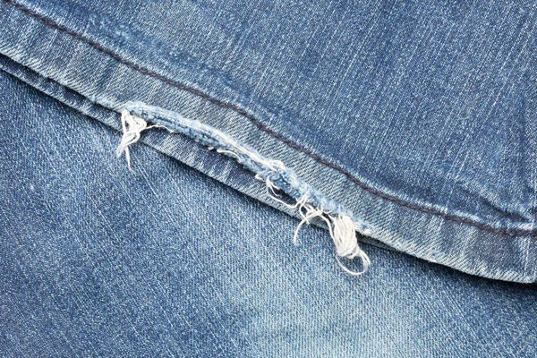 Blauw denim jeans gescheurde been close-up — Stockfoto