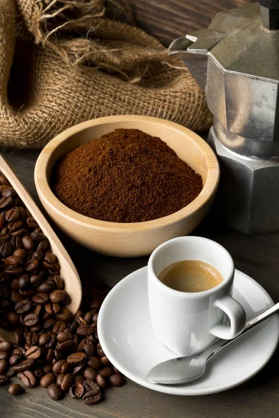 Chicchi di caffè, polvere di caffè macinato e tazza di caffè espresso con stov — Foto Stock