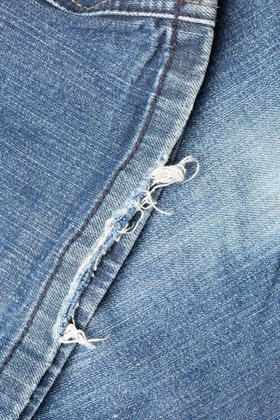 Blauw denim jeans gescheurde been close-up — Stockfoto