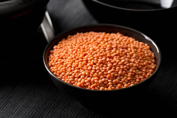 Raw red, dried  lentils in black bowl — Stock Photo, Image