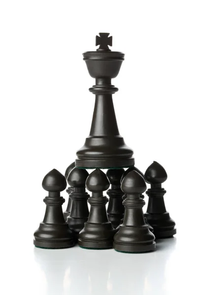 Rei figura de xadrez em cima de figuras de xadrez peão — Fotografia de Stock