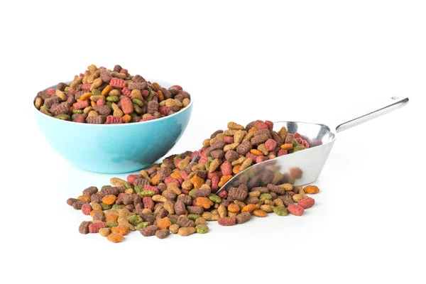 Heap de alimentos secos para animais de estimação em colher de metal e tigela de plástico — Fotografia de Stock