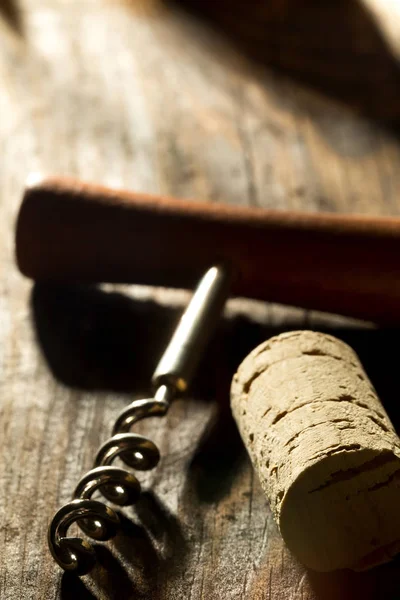 Corkscrew with wooden handle and corks from wine bottles on wood — Stock Photo, Image