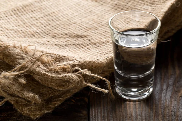 German hard liquor Korn Schnapps in shot glass on table — Stock Photo, Image