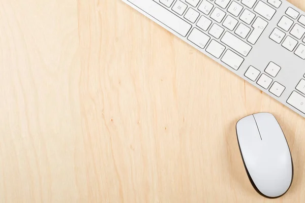 Brown wooden office desk top view with computer mouse and keyboa — Stock Photo, Image