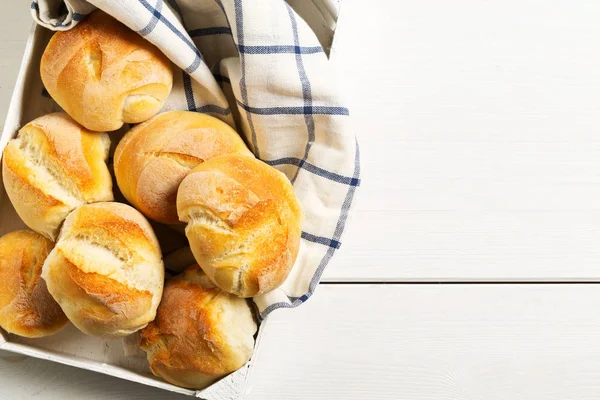 Bündel von ganzen, frisch gebackenen Weizenbrötchen mit Weizenähren auf weiß — Stockfoto