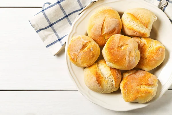 Bündel von ganzen, frisch gebackenen Weizenbrötchen mit Weizenähren auf weiß — Stockfoto