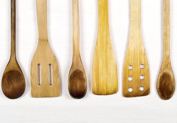Fila di utensili da cucina in legno con cucchiai e spatole dall'alto — Foto Stock