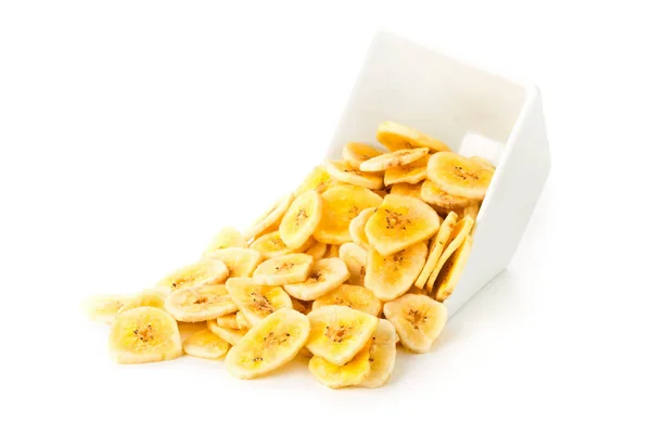 Heap of dried banana chips snack in white bowl over white — Stock Photo, Image
