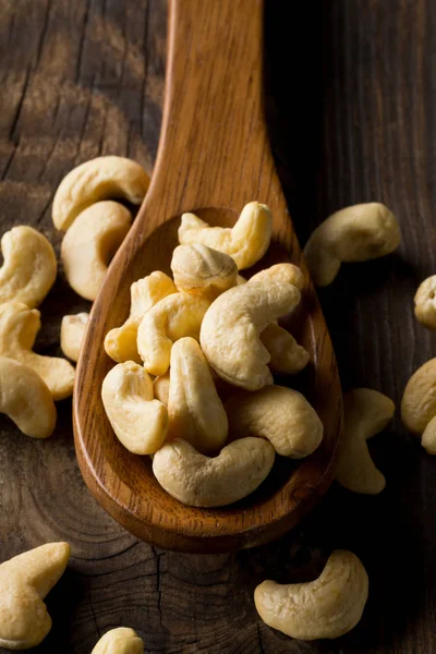 Haufen roher, biologischer, ganzer Cashewnusskerne im Holzlöffel — Stockfoto