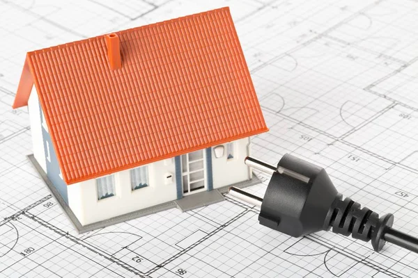 Power cord on building construction blueprint plan with model house — Stock Photo, Image