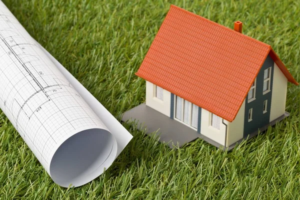 Modello di casa in miniatura con progetto architettonico su erba verde — Foto Stock
