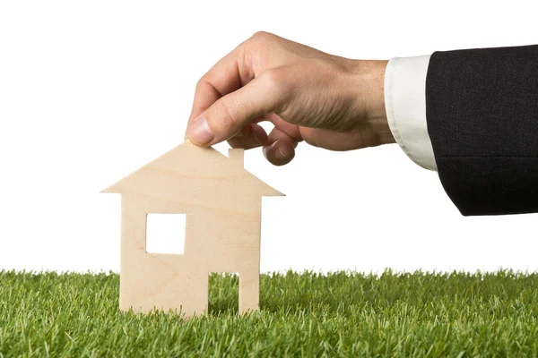 Business man holding little wooden miniature house model — Stock Photo, Image