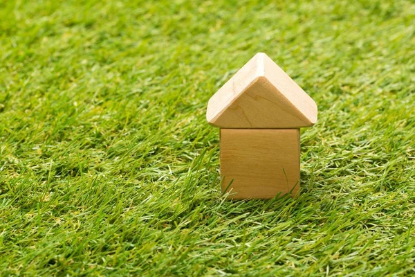 Little wooden miniature house model on green grass background — Stock Photo, Image