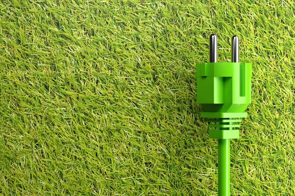 Green power cord with plug on grass background