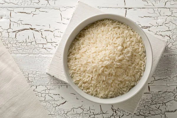 White uncooked, raw long grain rice in white bowl — Stock Photo, Image
